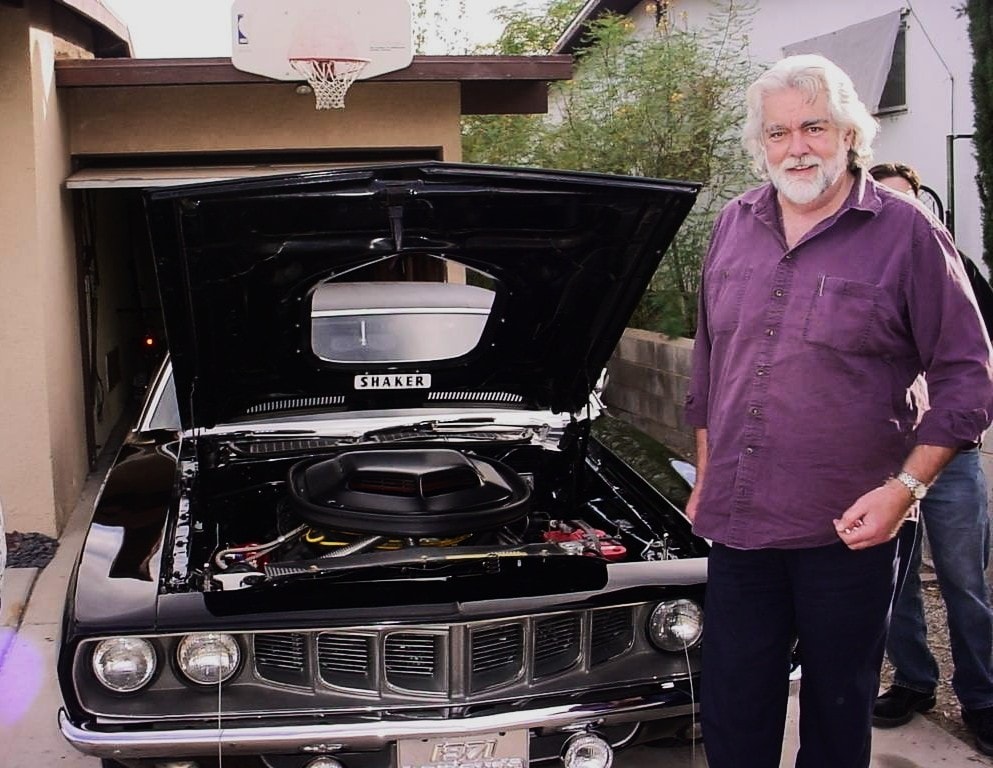 Gunnar Hansen standing with the Black Beast — hood open, 426 Hemi Shaker on full display, Las Vegas 2004 during the Murder-Set-Pieces production