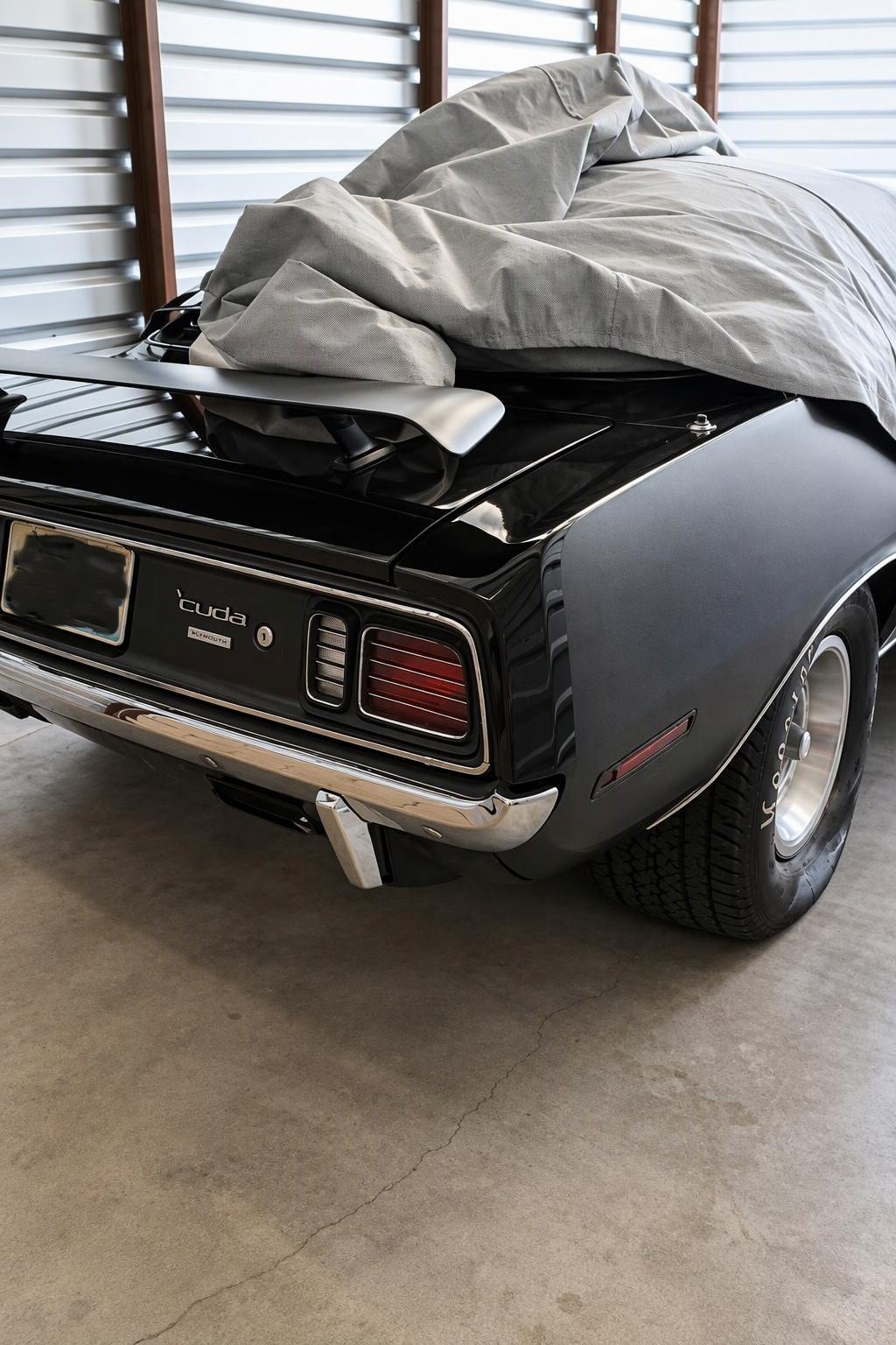 The Black Beast — TX9 triple-black 1971 Hemi Cuda coming out of storage, cover being pulled back to reveal the rear quarter panel and Cragar wheels