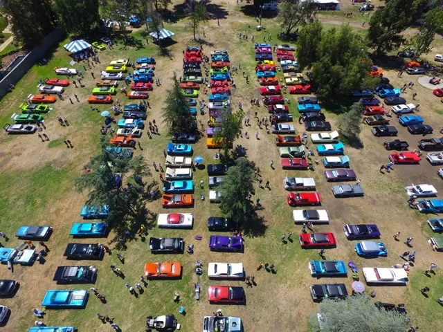 Aerial view of Spring Fling at Woodley Park — hundreds of Mopars and muscle cars filling the field, the Black Beast among them